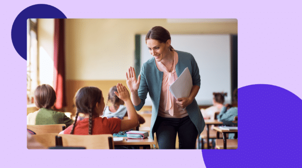 Female teacher high-fiving a student in a classroom