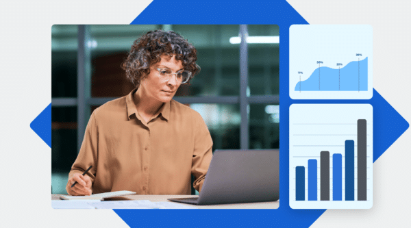 A professional administrator with curly hair, wearing glasses, working on a laptop while reviewing charts showcasing software performance data, including line and bar graphs.