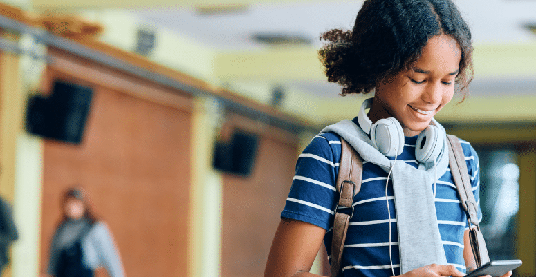 Young female student using texting with her smartphone.