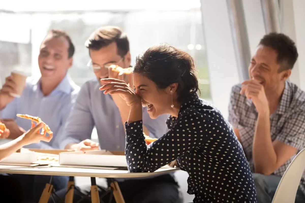 Group of people sitting at a table and laughing.