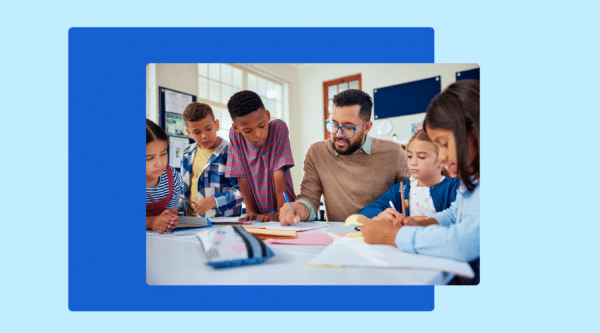Teacher assisting a diverse group of elementary students with their assignments in a classroom setting.